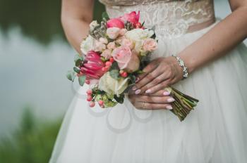 Bouquet in hands of bride.