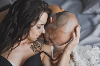 Close-up portrait of a bald brutal man kissing the girl shoulder.