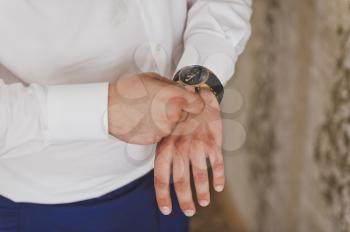 A man checks the time on a wristwatch.