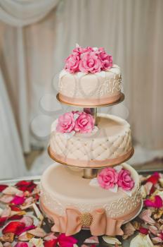 A three tiered cake with pink flowers.