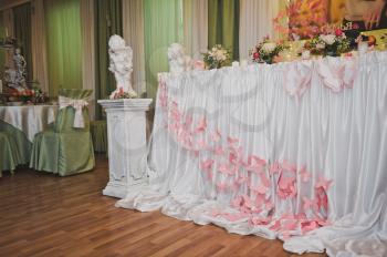 Festive tables decorated with cloth and flowers.