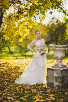The bride walks in the autumn garden.