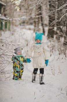 Portrait of young children on the background of snowy winter forest.