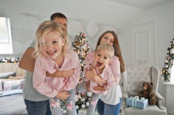 A young family with two daughters happily play in the room.