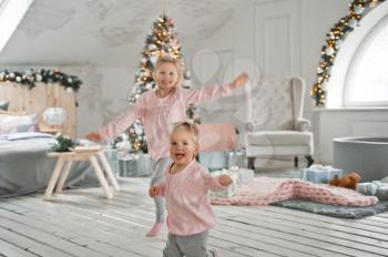 Girls frolic running around the decorated house.