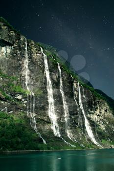 At night, under the light of stars. Geiranger fjord, Norway - waterfalls Seven Sisters.