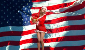 Girl dressed as Santa Claus on a background of the American flag