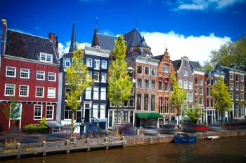 Beautiful view of Amsterdam canals with bridge and typical dutch houses. Holland
