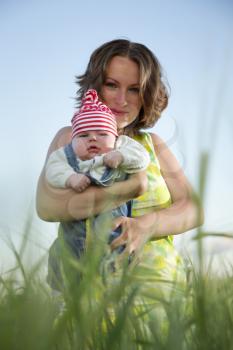 mother holding a baby in a field