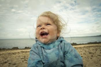 little girl laughing on the beach . summer vacation by the ocean