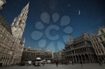 Grand Place - the historic square in the center of Brussels. Town Hall and the Bread House, or House of the King. moon and the stars shine in the night sky.