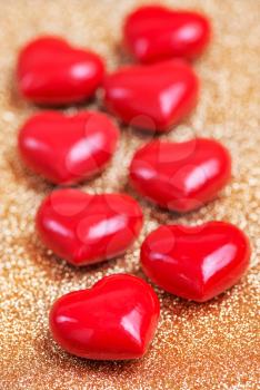 red hearts on a table, red hearts on golden background