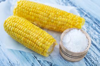 boiled corn with salt on a table