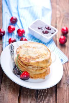 pancakes with cherry on the plate and on a table