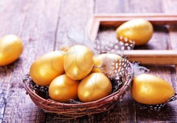 golden eggs in nest and on a table