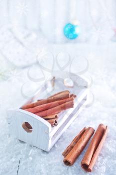 cinnamon sticks and christmas decoration on snow