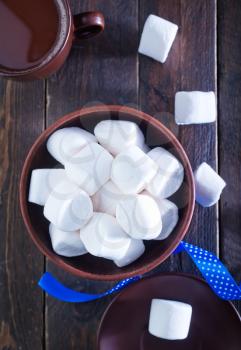 white marshmallows in the bowl and on a table