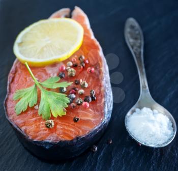 raw salmon steak with spice on the black board