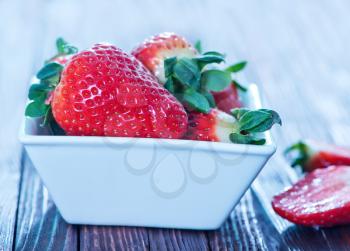 fresh strawberry in bowl and on a table