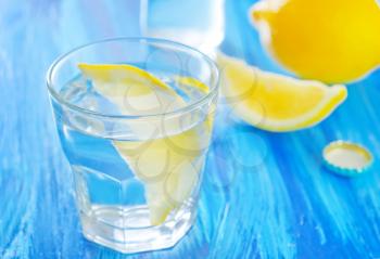 water with lemons in the glass and on a table