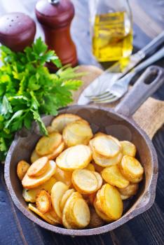 fried potato in pan and on a table