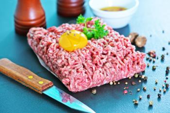minced meat with spice and raw egg on a table