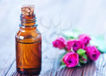 rose oil in bottle and on a table