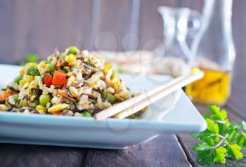 fried rice with vegetables on plate and on a table
