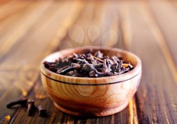 cloves in wooden bowl and on a table