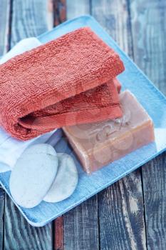 soap, stones and towels on the wooden plate