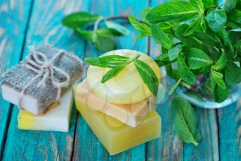 soap and mint leaves on the wooden table
