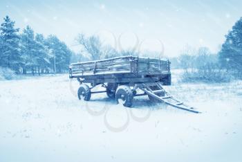 an old farm cart in the snow