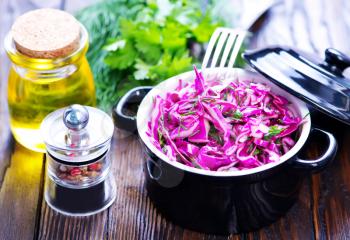 cabbage salad in plack bowl and on a table