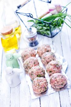 raw meat balls with spice on the foil