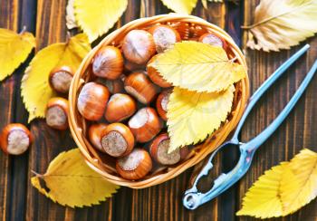 autumn leaves and hazelnuts on a table