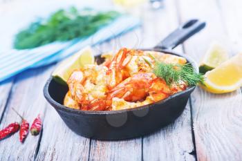 fried shrimps in pan and on a table