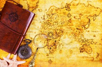 travel background, old notebook, loupe and compass on the map