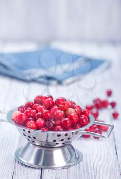 Cranberry in metal bowl and on a table