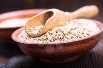 raw quinoa in the brown bowl and on a table