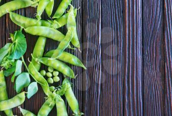 green peas on a table, fresh peas on the wooden background