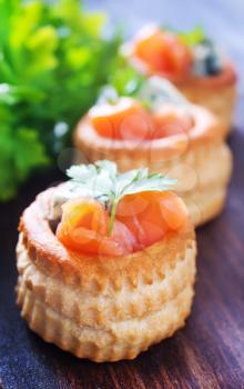 tartalets with salmon and butter on a table