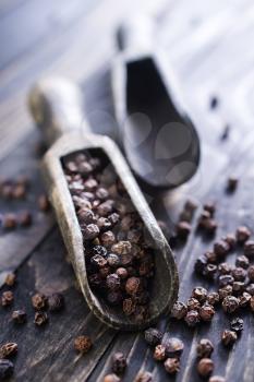 black spice and wooden spoons on a table
