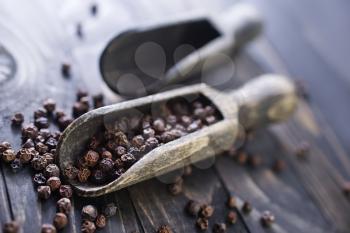 black spice and wooden spoons on a table