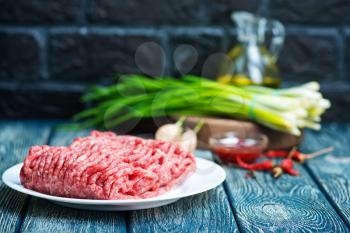 raw minced meat on plate and on a table
