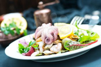 salad with seafood on plate and on a table
