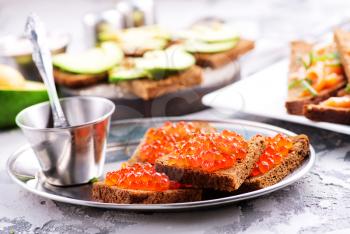 bread with red salmon caviar on a table