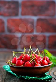 fresh cherry in bowl and on a table