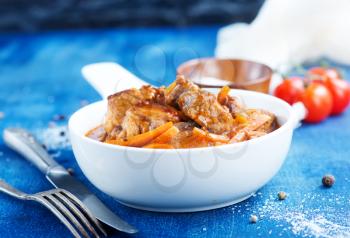 meat stew in white bowl and on a table