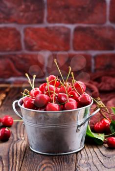 red cherry in bowl and on a table