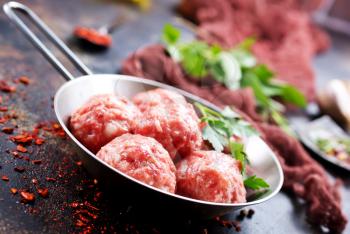 raw meatballs with salt and spice on a table